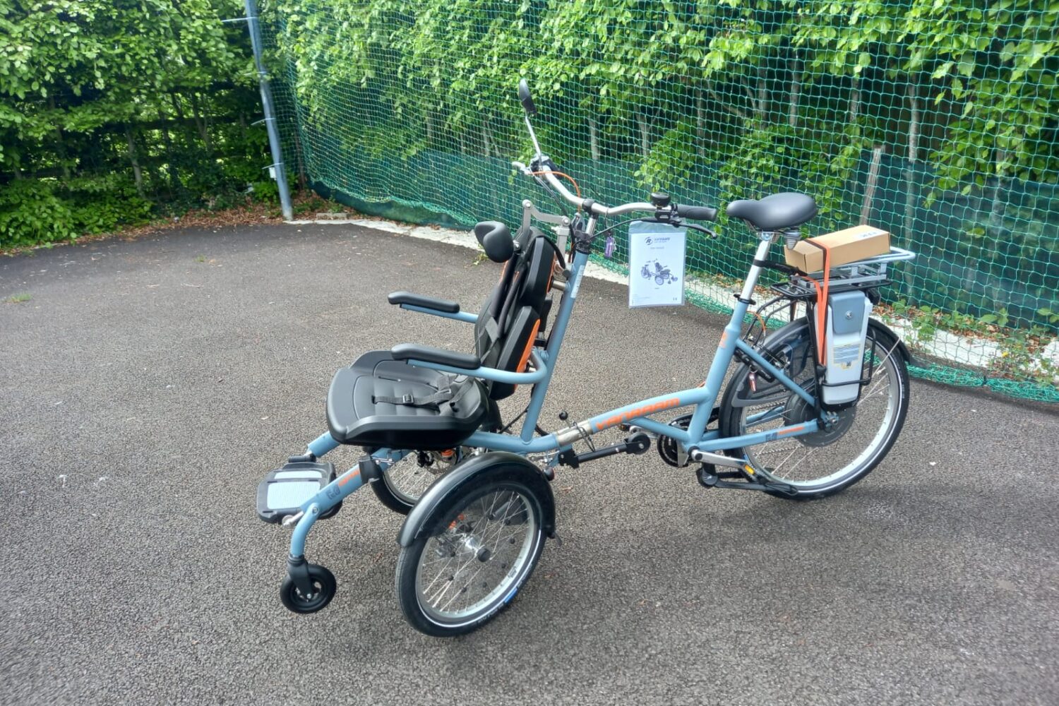 Blue accessible bicycle with two seats. Single seat at the front.