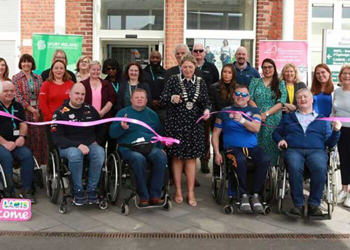 Mayor of Laois snips ribbon to accessible gym, surrounded by crowd and people in wheelchairs.