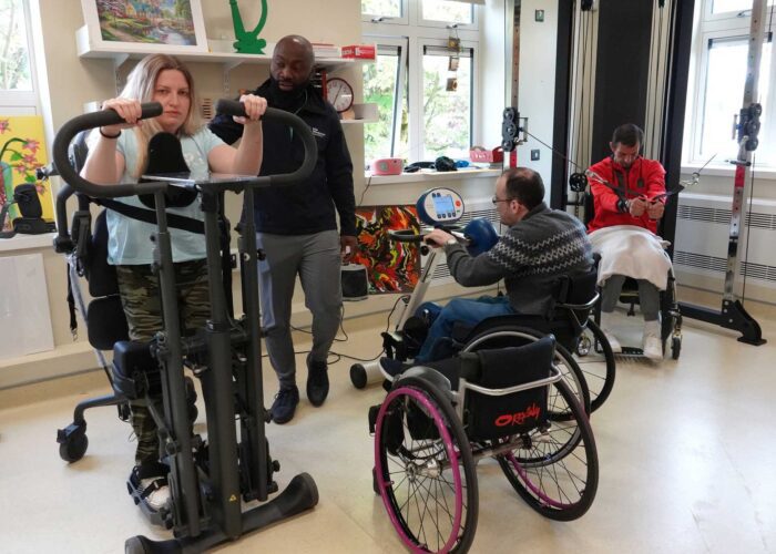 People with disabilities using equipment in an accessible gym.