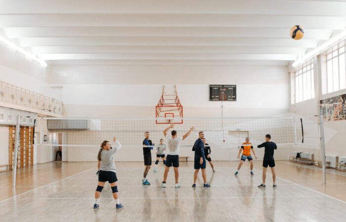 People playing volleyball in a gymnasium.